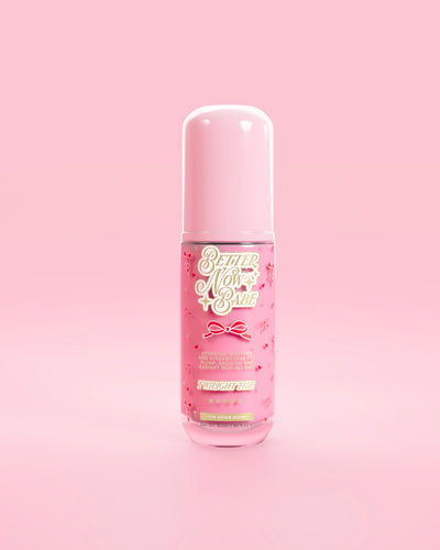 มองผ่านขวดสีชมพูของ P.Louise Better Now Babe เซรั่มซ่อมแซมผิวสีชมพูในกลิ่นพลบค่ำตัดกับพื้นหลังสีชมพู