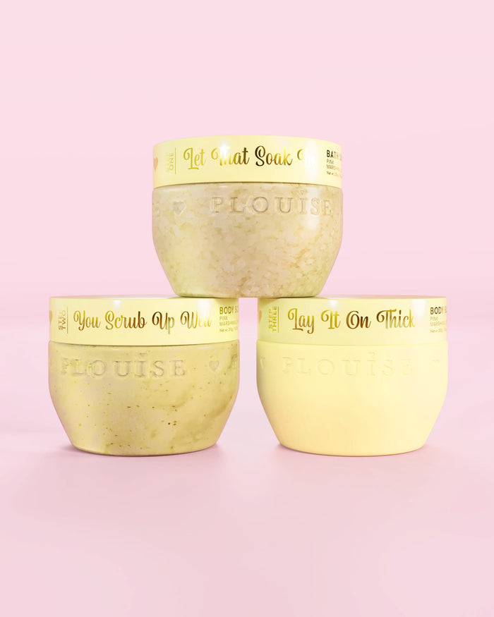 P.Louise Hop Into Self-Care Starwberry Shortcake สามขวดในภาชนะสีเหลือง ประกอบด้วยเกลืออาบน้ำ สครับขัดผิว และบอดี้บัตเตอร์ พร้อมข้อความสีทองบนพื้นหลังสีชมพู