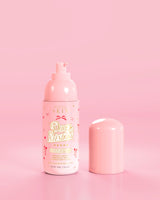 ขวดสีชมพูของ P.Louise Pure Intentions Purify & Brightening Lotion ดีไซน์โบว์สีแดงตัดกับพื้นหลังสีชมพู