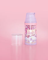 ขวดสีม่วงของ P. Louise Here I Glow Again Grape Recovery Mask บนพื้นหลังสีชมพู