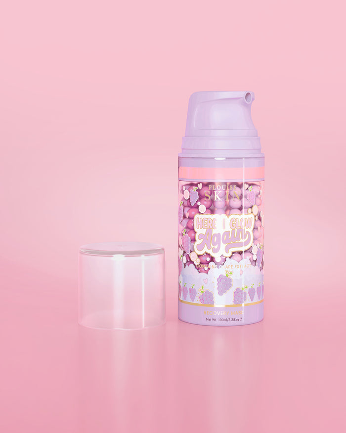 ขวดสีม่วงของ P. Louise Here I Glow Again Grape Recovery Mask บนพื้นหลังสีชมพู
