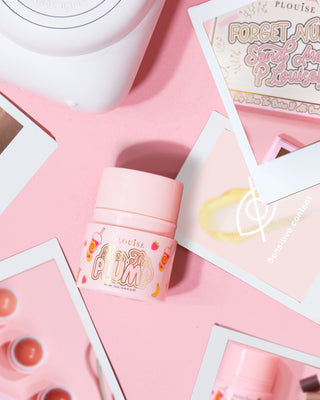 ขวดสีชมพูของ P.Louise Pass The Plump Lip Treatment บนพื้นหลังสีชมพู