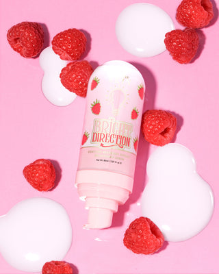 Pink P.Louise Bright Direction Raspberry Brightening Serum ผลิตภัณฑ์บำรุงผิวดีไซน์ราสเบอร์รี่ล้อมรอบด้วยราสเบอร์รี่บนพื้นหลังสีชมพู