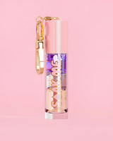 P. Louise Soak Me Lip Oil ที่มาพร้อมออยล์หลากสีสันในหลอดสีชมพู พร้อมด้วยเข็มกลัดสีทองบนพื้นหลังสีชมพู
