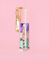 P. Louise Soak Me Lip Oil ที่มาพร้อมออยล์หลากสีสันในหลอดสีชมพู พร้อมด้วยเข็มกลัดสีทองบนพื้นหลังสีชมพู