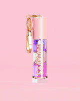 P. Louise Soak Me Lip Oil ที่มาพร้อมออยล์หลากสีสันในหลอดสีชมพู พร้อมด้วยเข็มกลัดสีทองบนพื้นหลังสีชมพู