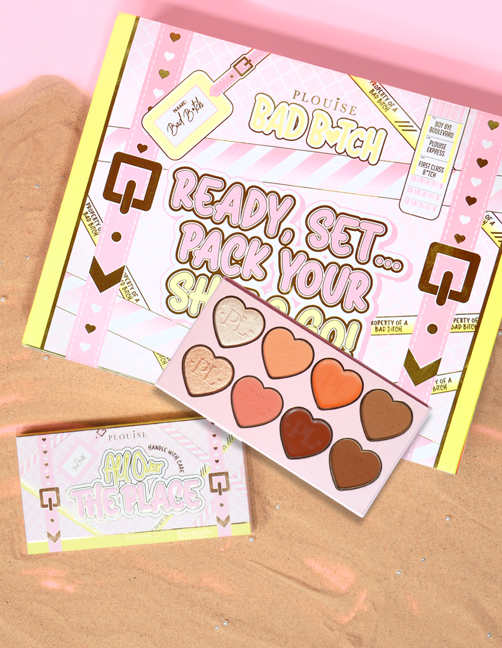 บรรจุภัณฑ์และผลิตภัณฑ์ P.Louise All Over The Place Face Palette จัดแสดงด้วยถาดรูปหัวใจหลากสีสันบนพื้นทราย