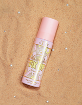 ขวดสเปรย์ P.Louise Fix Up Mattifying Setting Spray พร้อมฝาสีชมพูและลวดลายตกแต่งบนฉลาก จัดแสดงบนพื้นผิวทราย
