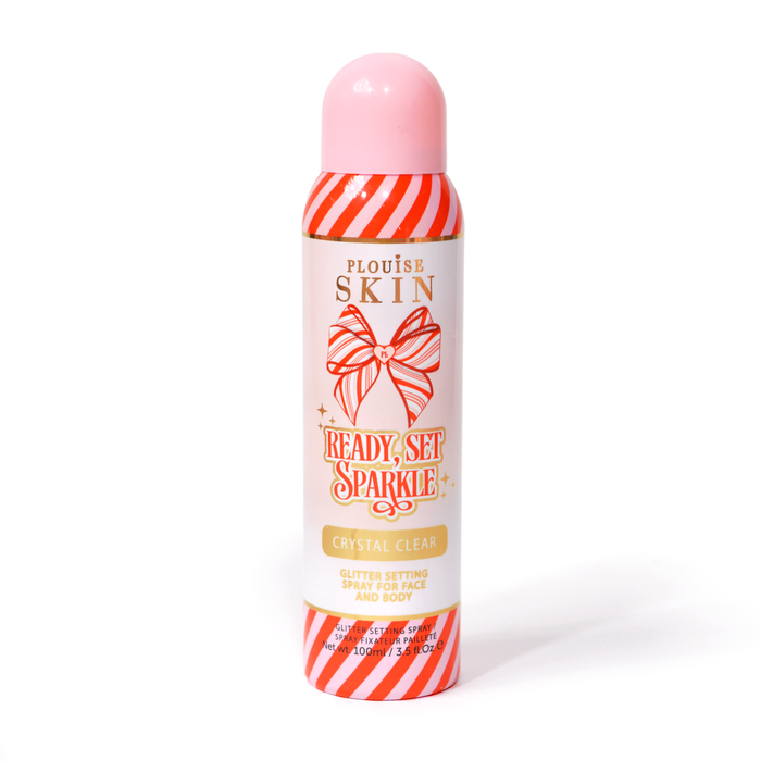 ขวดของ P. Louise Ready Set Sparkle Christmas Glitter Setting Spray ที่มีแถบสีแดงและชมพูบนขวด และโบว์ลายทางสีแดงและชมพูบนพื้นหลังสีขาว