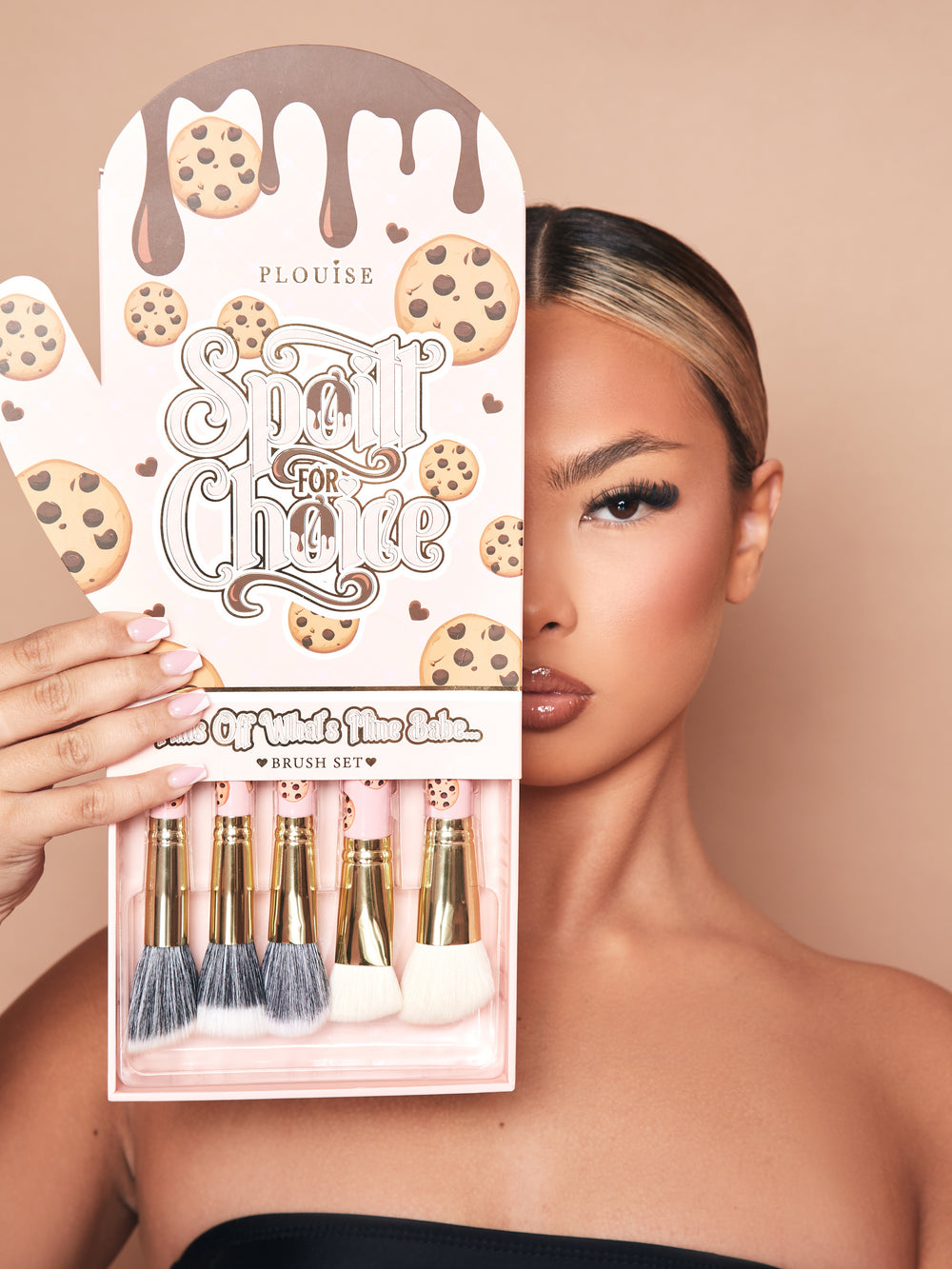 รูปภาพของชุดแปรงแต่งหน้า P.Louise Spoiled For Choice 5 Piece ในกล่องบรรจุภัณฑ์นวมเตาอบพร้อมถาดดึงด้านล่างออกเพื่อแสดงแปรงบางส่วน บรรจุภัณฑ์เป็นรูปนางแบบครึ่งหน้ากำลังแต่งหน้า
