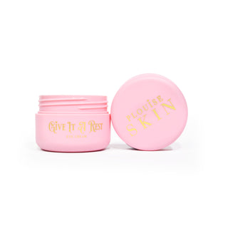 A pink open jar of P.Louise Give It A Rest Eye Cream showing the lid and jar from the sidewith the branding and product name on the jar in gold writing