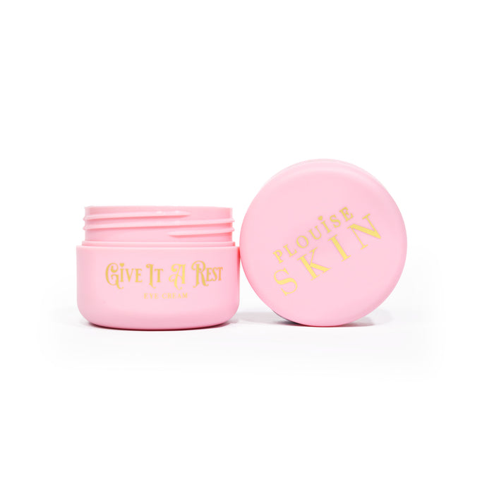 กระปุกเปิดสีชมพูของ P.Louise Give It A Rest Eye Cream โชว์ฝาและกระปุกด้านข้างพร้อมแบรนด์และชื่อผลิตภัณฑ์บนกระปุกเขียนด้วยสีทอง